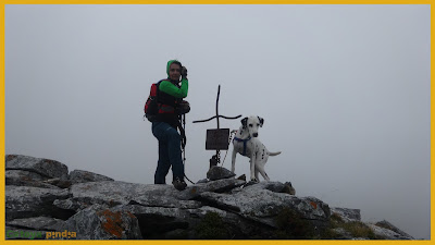 Vistas a la cruz de cumbre en las Peñas de Faro bajo la niebla