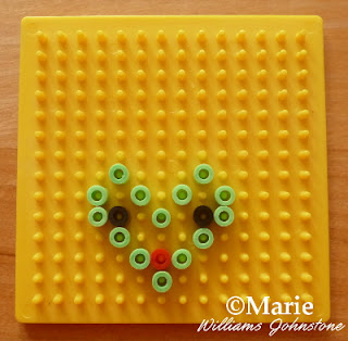 Yellow peg board with different color beads