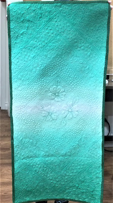 A table runner of free motion quilted green ombre` fabric