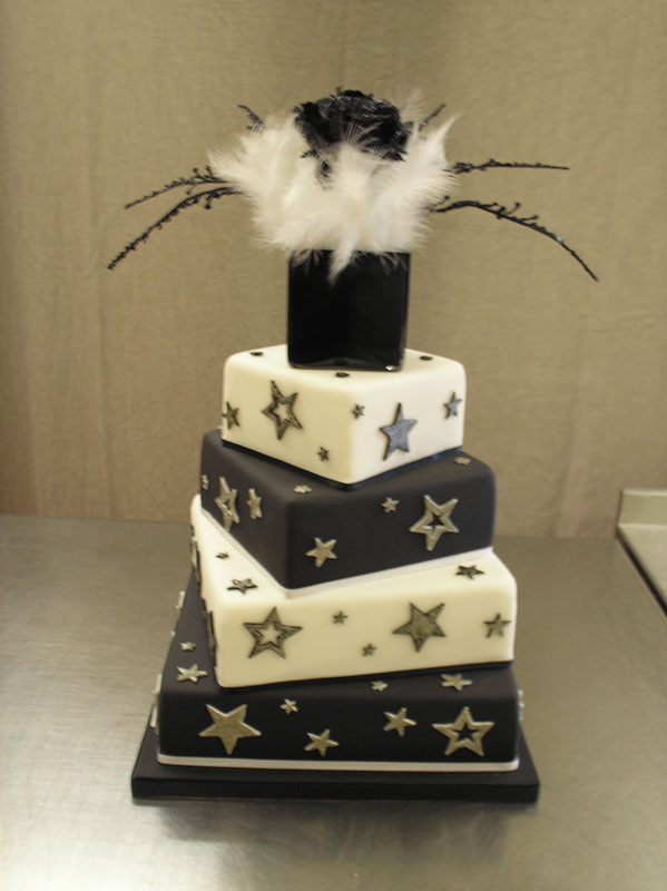 4 tier square cake with interesting unique topper