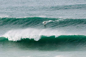 Surfer riding big waves in Newquay Cornwall