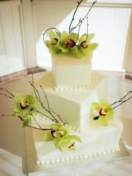 Four tier square white wedding cake with fresh green orchids