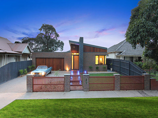 Picture of small family home with blue Ford Mustang in front