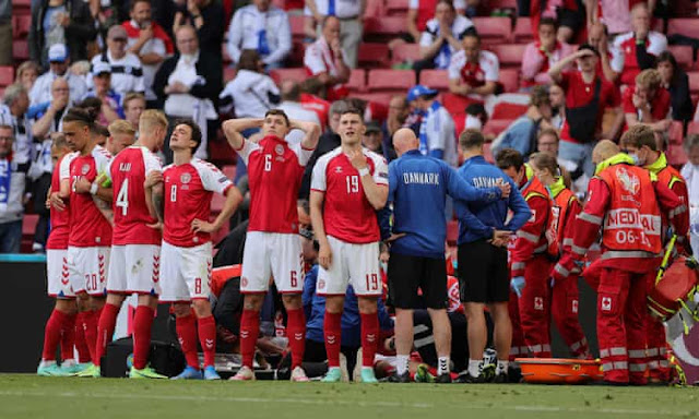 Denmark players protecting Christian Eriksen from the camera