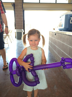 A little girl strumming her balloon guitar