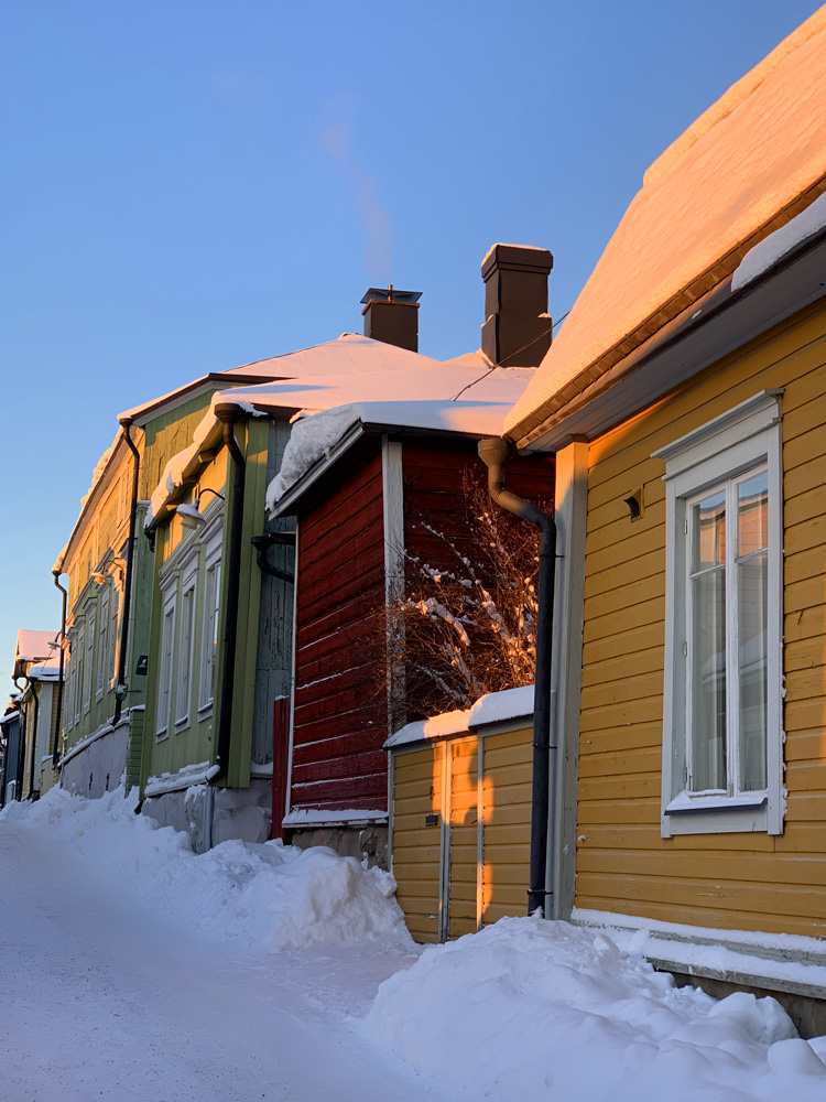 Yellow, red and green wooden house and a lot of snow