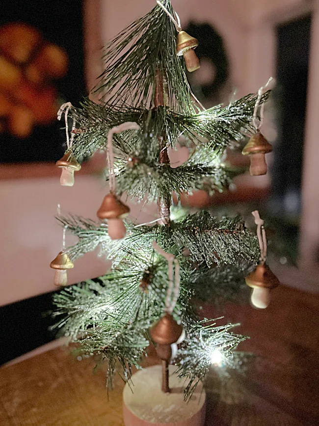 mini mushroom ornaments on lit tree