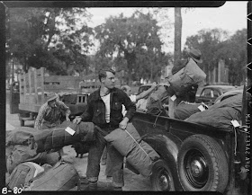 A man hauling packs into the back of a truck.