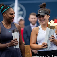 Canadian tennis star Bianca Andreescu celebrates with the Rogers Cup trophy as Serena Williams looks on after retiring from the final with injury