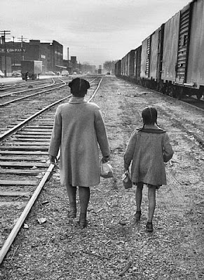 Black and white photo of 2 girts, the Brown sisters,  walking along railroad tracks