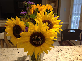 beautiful sunflowers and purple flowers in a vase