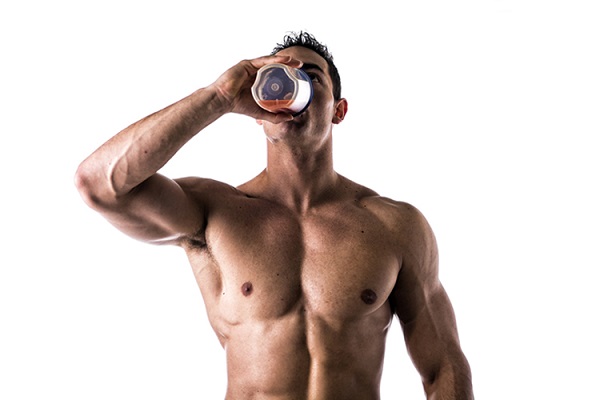 Hombre musculoso sin camiseta bebiendo un batido de proteínas