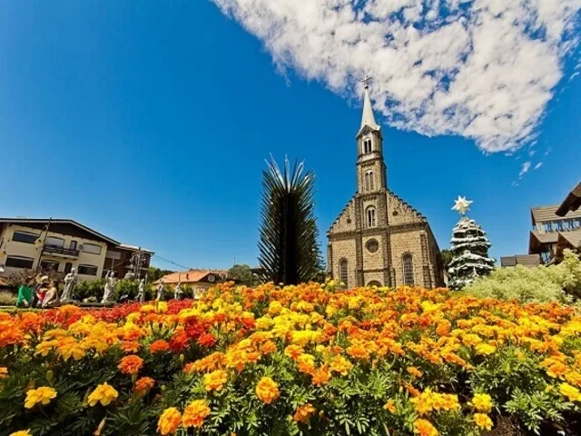 Igreja e pedra, gramado e praça florida