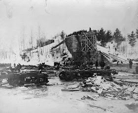 A photograph of trucks and debris on snow.
