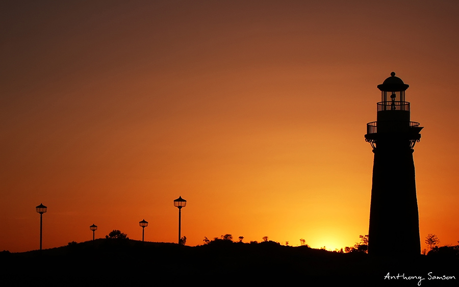 Beautiful sunset photo with light house as silhoute