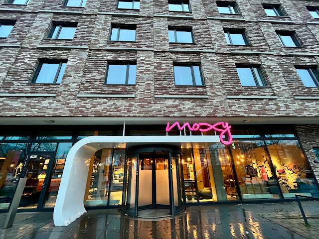 A bright Moxy sign at the hotel entrance