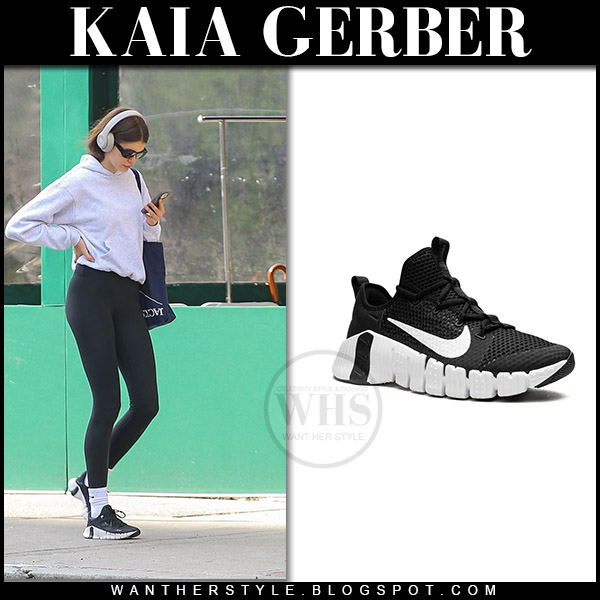 Kaia Gerber in grey sweatshirt, black leggings and black sneakers