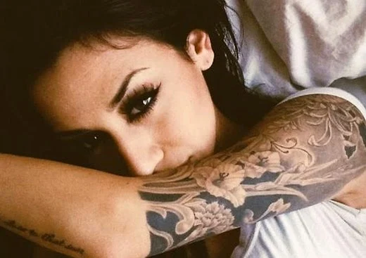 vemos una chica con un tatuaje en su brazo