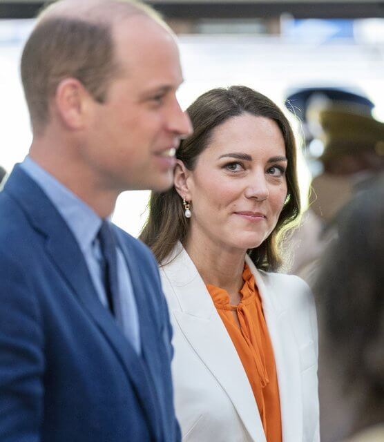 Kate Middleton wore a tangerine silk crepe de chine top by Ridley London, and white crape blazer by Alexander McQueen