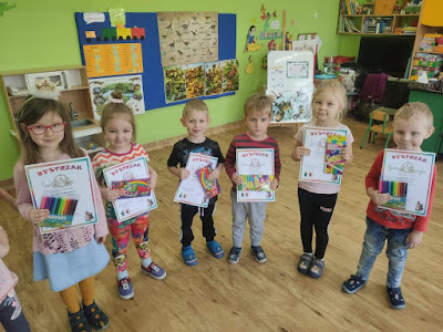 Zdjęcie dzieci stojących z dyplomami i nagrodami w rękach