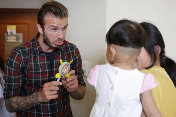 David Beckham pulls funny face for children in Chinese hospital