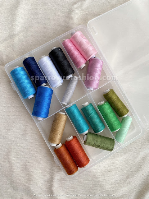 spools of thread, a box with spools is on the table