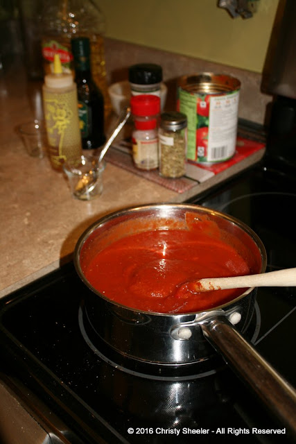 Pizza sauce in a pan warmed on the stove.