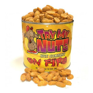 a yellow tin labeled "Try My Nuts on Fire." The tin is full of peanuts. 