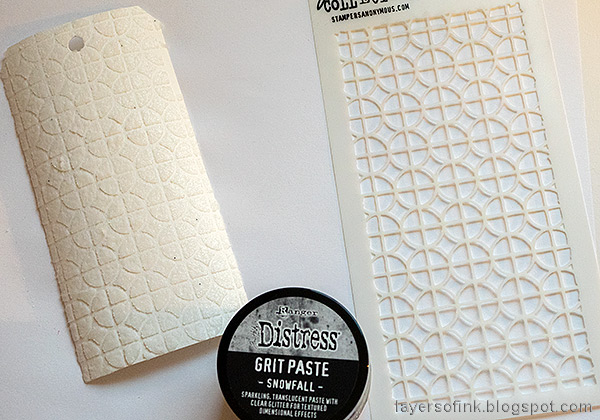 Layers of ink - Foil Snowflake Tag Tutorial by Anna-Karin Evaldsson. Apply grit paste through Tim Holtz Focus stencil.