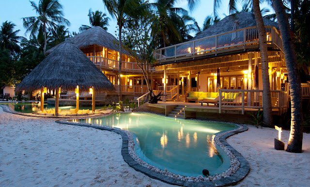 Photo of large resort residence at sunset with sand and swimming pool