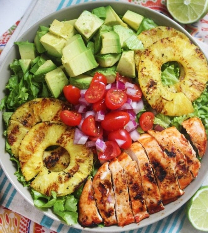 This Sriracha Lime Grilled Chicken Salad is bursting with flavor. Spicy grilled chicken, sweet and juicy grilled pineapple, crisp lettuce, tomatoes, avocado, and a sweet and tangy lime vinaigrette. Ingredients  SRIRACHA LIME CHICKEN:  2 chicken breasts 1 pound 3 tablespoons sriracha 1 lime juiced 1/4 teaspoon fine sea salt 1/4 teaspoon freshly ground pepper SALAD:  4 cups lettuce chopped 8 pineapple slices using pineapple corer 1 cup organic grape tomatoes 1/3 cup red onion finely chopped 1 avocado cubed LIME VINAIGRETTE:  1/3 cup olive oil 1/4 cup apple cider vinegar 2 limes juiced 2 teaspoons honey Dash fine sea salt Instructions  Heat the grill to medium heat.  Season chicken with salt and pepper. In a bowl or marinade dish, combine sirarcha and lime.  Add chicken and let marinade in the fridge for at least 20 minutes, the longer the better.  Once ready to cook, add chicken to the greased grill.  Cut pineapple into 1" rings using pineapple corer or the above method and add to grill, grill for 3-4 minutes on each side.  While they are grilling, chop lettuce, then chop avocado, tomato, and red onion and add to serving dish.  Whisk together dressing, taste, and adjust seasoning as desired (i.e. more lime, additional sea salt, additional vinegar)- place in fridge until ready to use.  Once chicken is done cooking, assemble the salad, toss with dressing and enjoy!