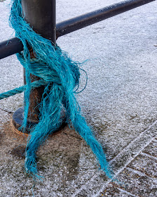Photo of the frayed end of a bright blue mooring rope
