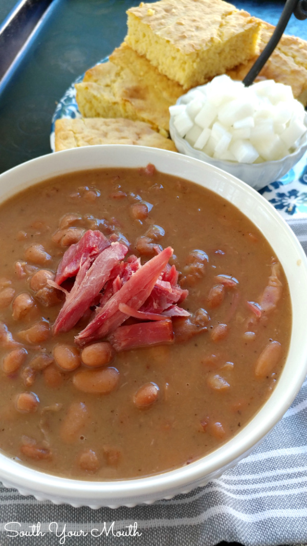 Slow Cooker Pinto Beans! Creamy, tender pinto beans cooked in the crock pot with smoky ham hocks or leftover ham with a silky sauce perfect with cornbread or over rice (stove-top instructions included).