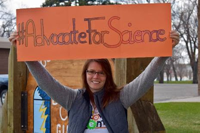 Photo of person holding sign saying hashtag Advocate For Science