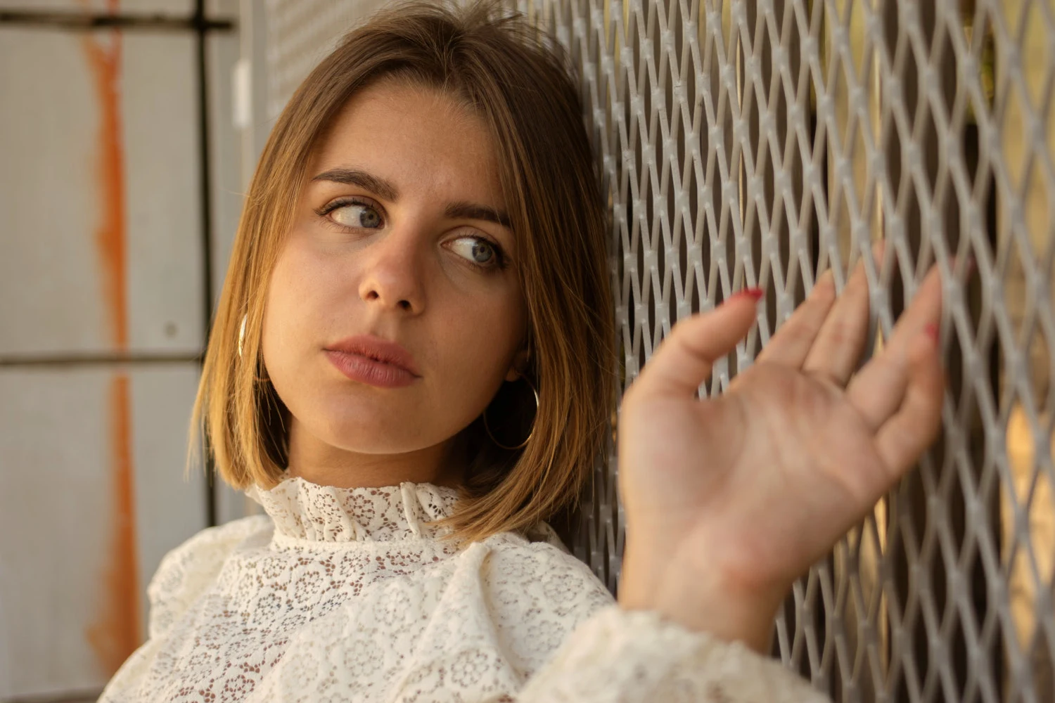 woman in lace blouse is wearing hoop earrings