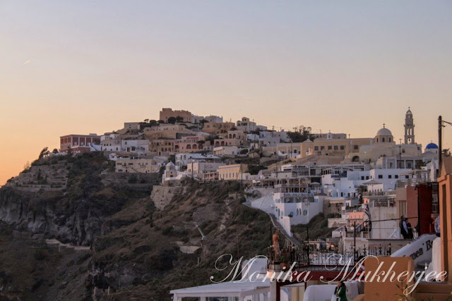 Santorini Sunset Greece by Monika Mukherjee