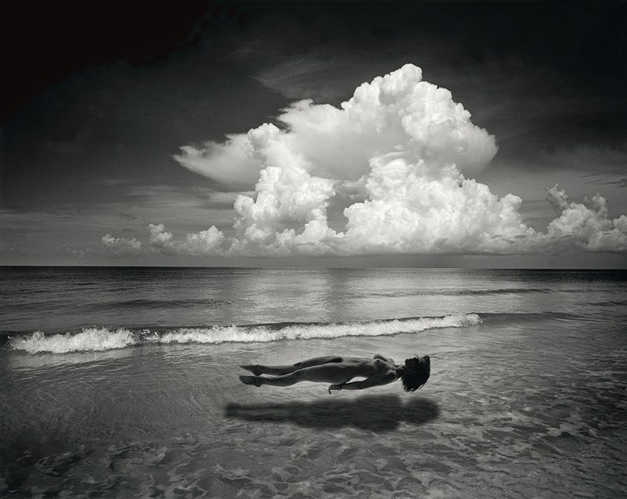 Woman levitating above the shore