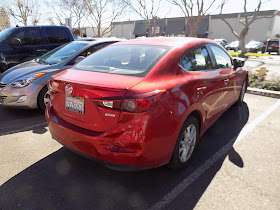Mazda 3 with crushed bumper & 3-stage Soul Red paint before repairs at Almost Everything Auto Body.