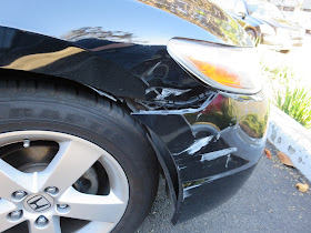 Honda Civic with damaged front bumper, fender and headlight.