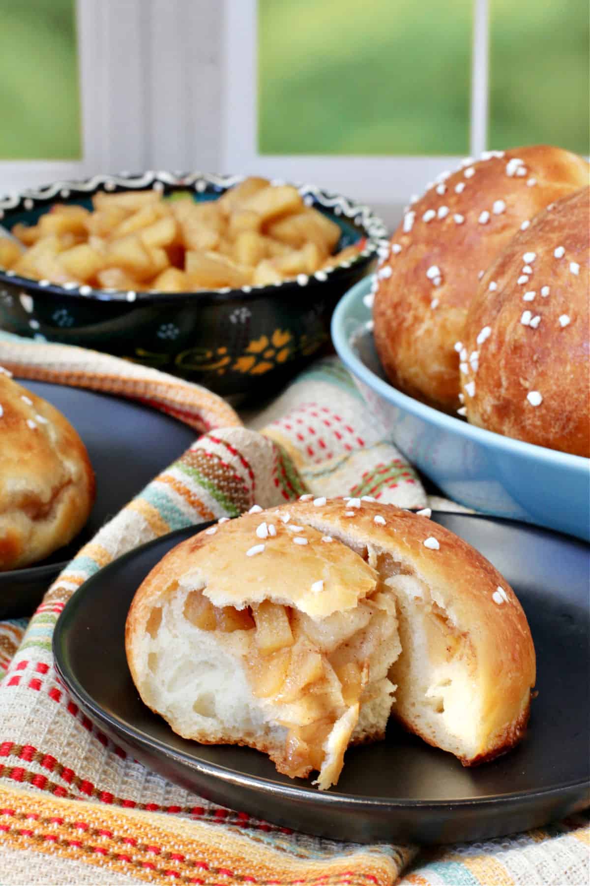 Apple Buns with one on a plate showing the apples inside.