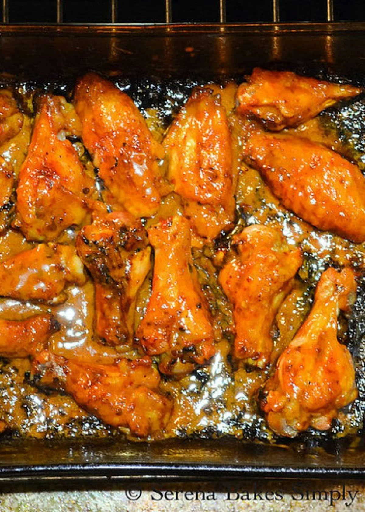 A glass pan full of Honey Chipotle Baked Chicken Wings.