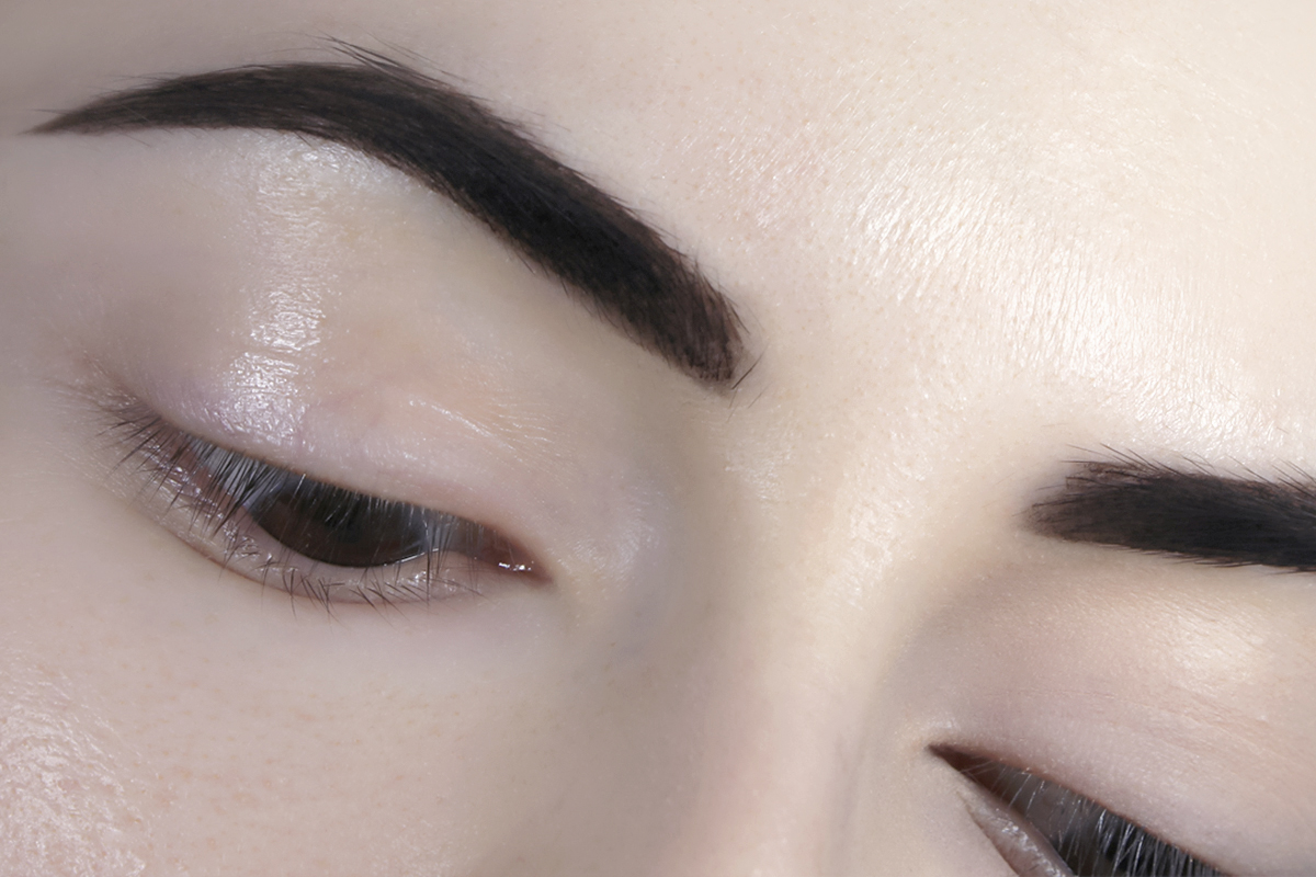 close-up crop of eyes and eyebrows with henna dye on them