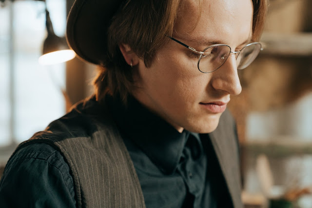 Stylish man wearing glasses and a black vest top.