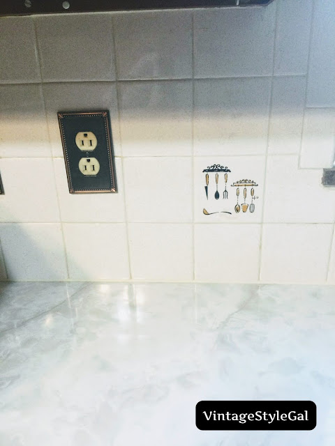 Utensils on accent tile in kitchen