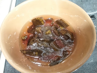 Yellow ware pottery bowl with chunks of watermelon rind in a sugar syrup.