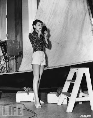 Hepburn adjusts her makeup on the set of Sabrina 1954