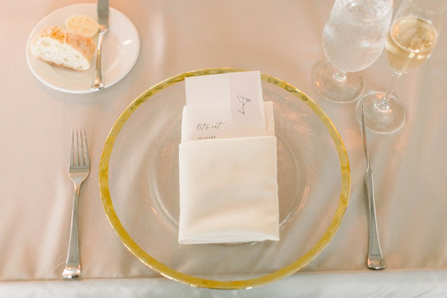 gold rimmed charger at wedding reception table
