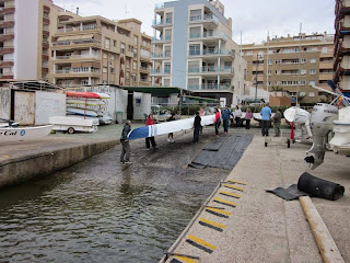 Las participantes de las prácticas de remo introduciendo el falucho en el agua