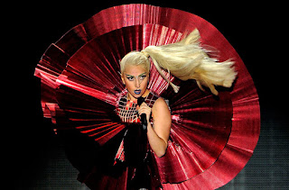 Image of lady gaga singing born this way live on stage while modeling