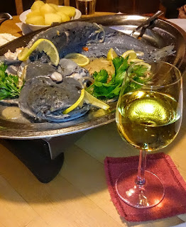 A plate with a catfish together with a glass of Riesling